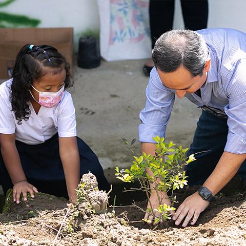 Leopoldo Báez y estudiante plantando juntos en el espacio destinado a TINI.