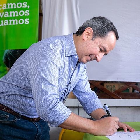 Leopoldo Báez firmando el compromiso del cuidado de la huerta.