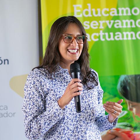 Mujer habla ante estudiantes y participantes durante la actividad.