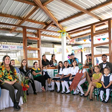 Estudiantes y adultos reunidos en un espacio escolar durante la ceremonia.