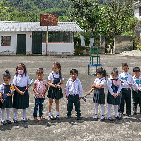 Estudiantes y adultos participan en la ceremonia de entrega de un espacio TINI frente a la escuela.