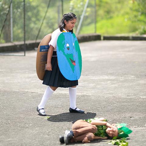 Estudiante disfrazada de elemento de la naturaleza participa en una actividad educativa.