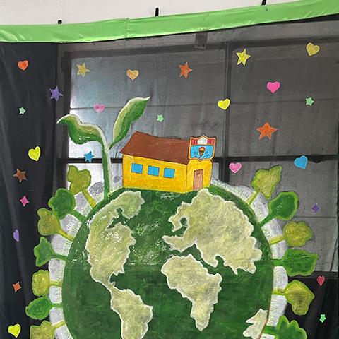 Fotografía de un planeta tierra y plantas alrededor hecho por los estudiantes.